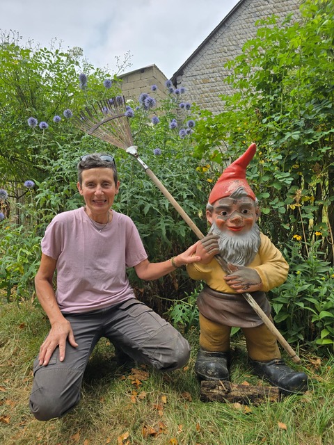 Claudia Stein mit einem Gartenzwerg in ihrem Garten